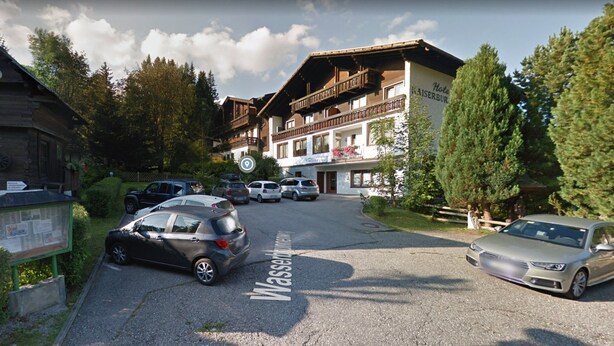 Un hotel llamado 'Hotel Kaiserburg' con un cartel que indica 'Wasserburg' en la carretera.