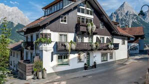 A traditional chalet with a steep roof, large windows, and balconies with plants. - Amazing Apartment in Tyrol With Sauna (Lermoos)