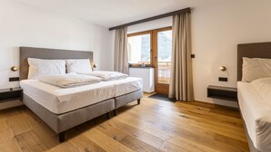A modern bedroom with a large bed, wooden flooring, and a view of a balcony. - Amazing Apartment in Tyrol With Sauna (Lermoos)