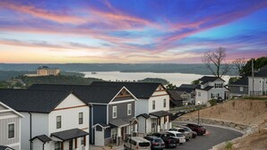 A residential area with houses, a parking lot, and a body of water in the background. - Cm132-6 -summer Breeze- Sleeps 17 6 Bedroom Home (Branson)