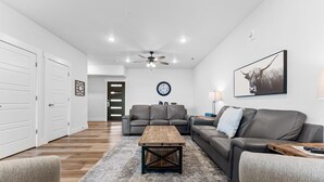 A modern living room with a wooden coffee table, leather sofas, and a large wall clock. - Cm132-6 -summer Breeze- Sleeps 17 6 Bedroom Home (Branson)