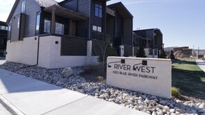 Ein modernes, zweistöckiges Haus mit einem Schild, auf dem 'River West 930 Blue River Parkway' steht.