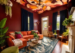 A living room with a sofa, chairs, a coffee table, and a patterned rug. - "La Lune Noire NOLA" (New Orleans)