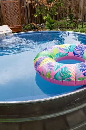 A swimming pool with a colorful inflatable ring. - Delightful Design & Cowboy Pool by French Quarter (New Orleans)