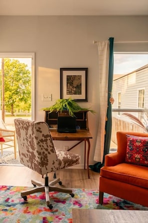 Una habitación con escritorio, silla y vista al exterior.