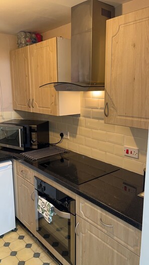 Een blender, kookgerei, borden en bestek, keukenpapier