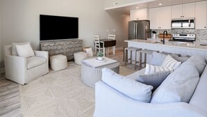 Ein modernes Wohnzimmer mit einer Couch, einem Couchtisch und einem Fernseher.