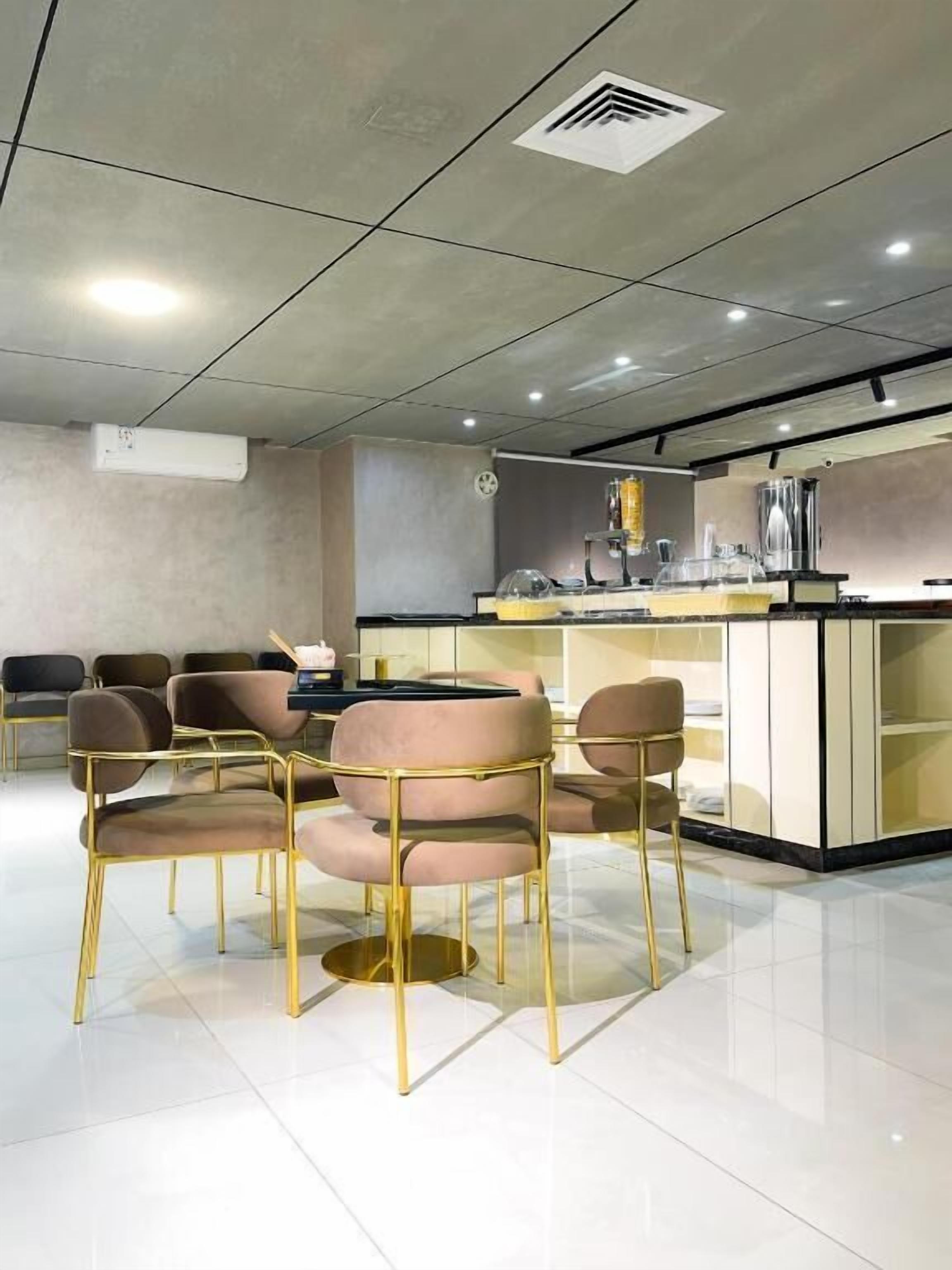 Et moderne spiseområde med en central ø, runde borde og stole.