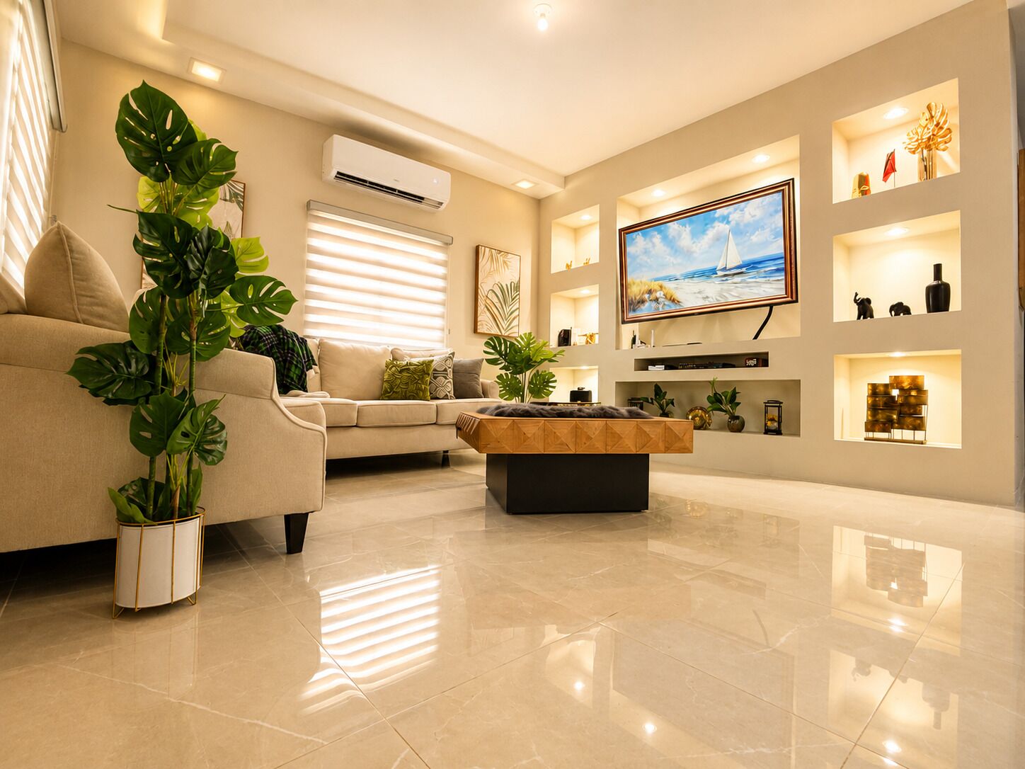 A modern living room with a beige sofa, a coffee table, and a flat-screen TV mounted on the wall.