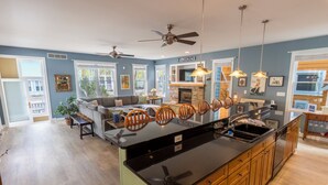 Une cuisine moderne dotée d’un îlot central, de meubles en bois et d’une cheminée en pierre.