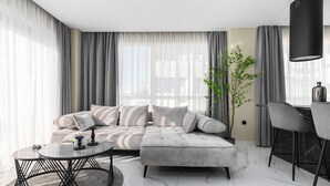 Una sala moderna con un sofá modular, una mesa de centro redonda y un comedor con sillas.