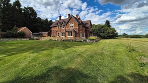 A large brick house with a well-maintained lawn in front.