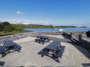 Un espace de pique-nique avec des murs en pierre et des bancs donnant sur un lac.