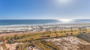 Blick auf die Küste mit Strand, Palmen und blauem Himmel.