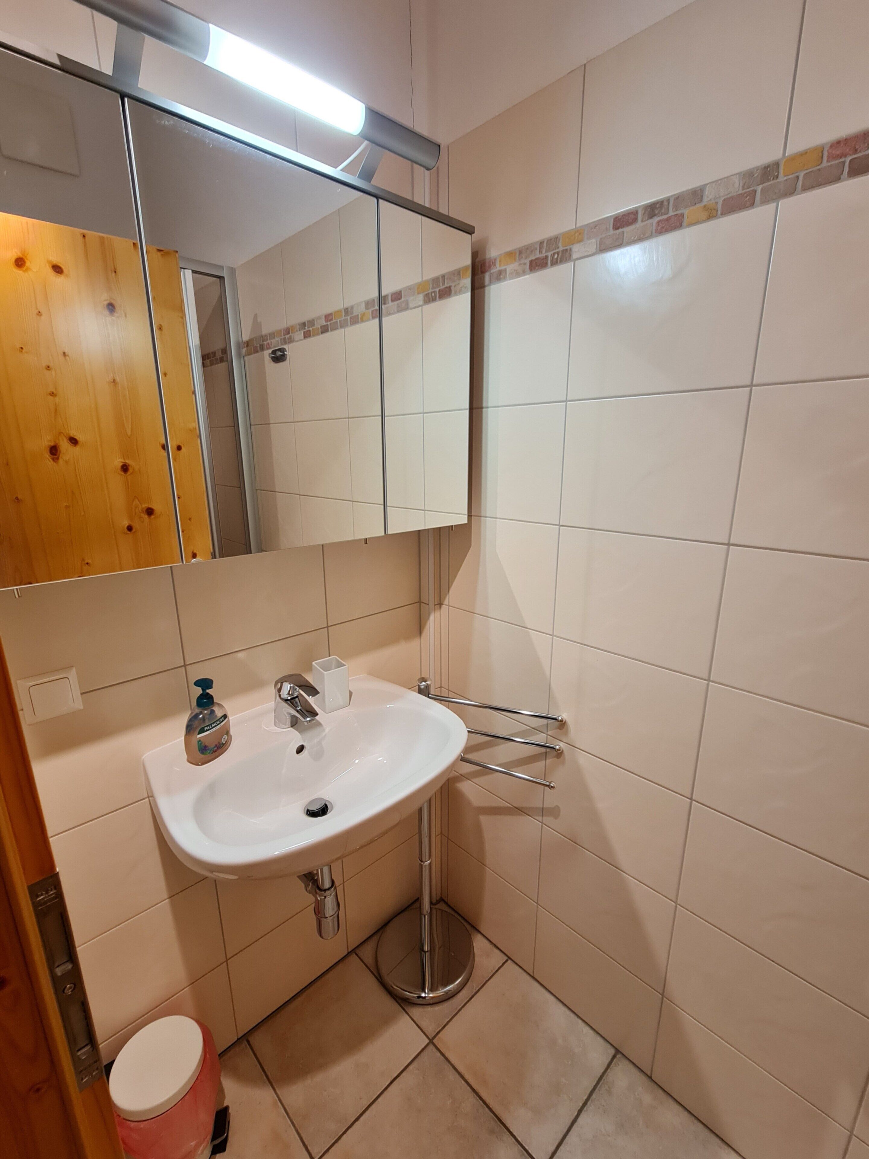 A bathroom with a white sink, a mirror, and a toilet.