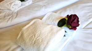 A neatly made bed with white linens and a single red rose placed on the pillow. - Beautiful Apartment in Bad Kleinkirchheim (Bad Kleinkirchheim)