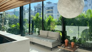 Una sala de estar moderna con una lámpara redonda grande, un sofá color beige y una mesa de centro con adornos.