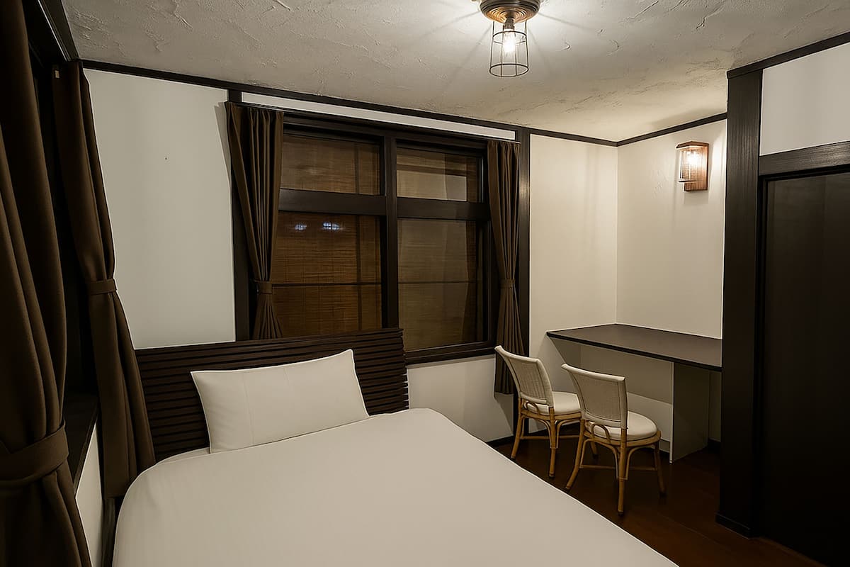 A hotel room with a bed, a desk, and a chair.