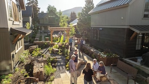 Ein Innenhof mit Steinwegen, einer Pergola und einer Gruppe von Menschen.