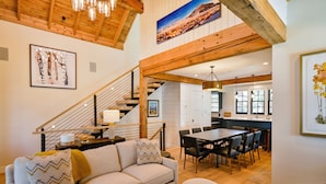 A spacious living area with a sofa, dining table, and staircase.