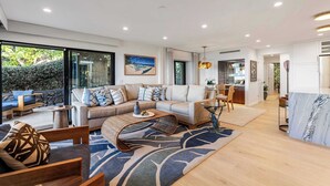 A modern living room with a sofa, coffee table, and a view of the outdoors. - Wailea Elua condo - Ocean Views | Gym | Pickleball (Wailea-Makena)