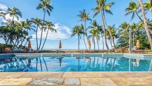 A pool with clear blue water, surrounded by palm trees and lounge chairs. - Wailea Elua condo - Ocean Views | Gym | Pickleball (Wailea-Makena)