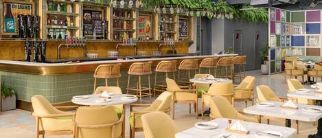 Zona de bar con diversas opciones de asientos y una variedad de grifos de cerveza.