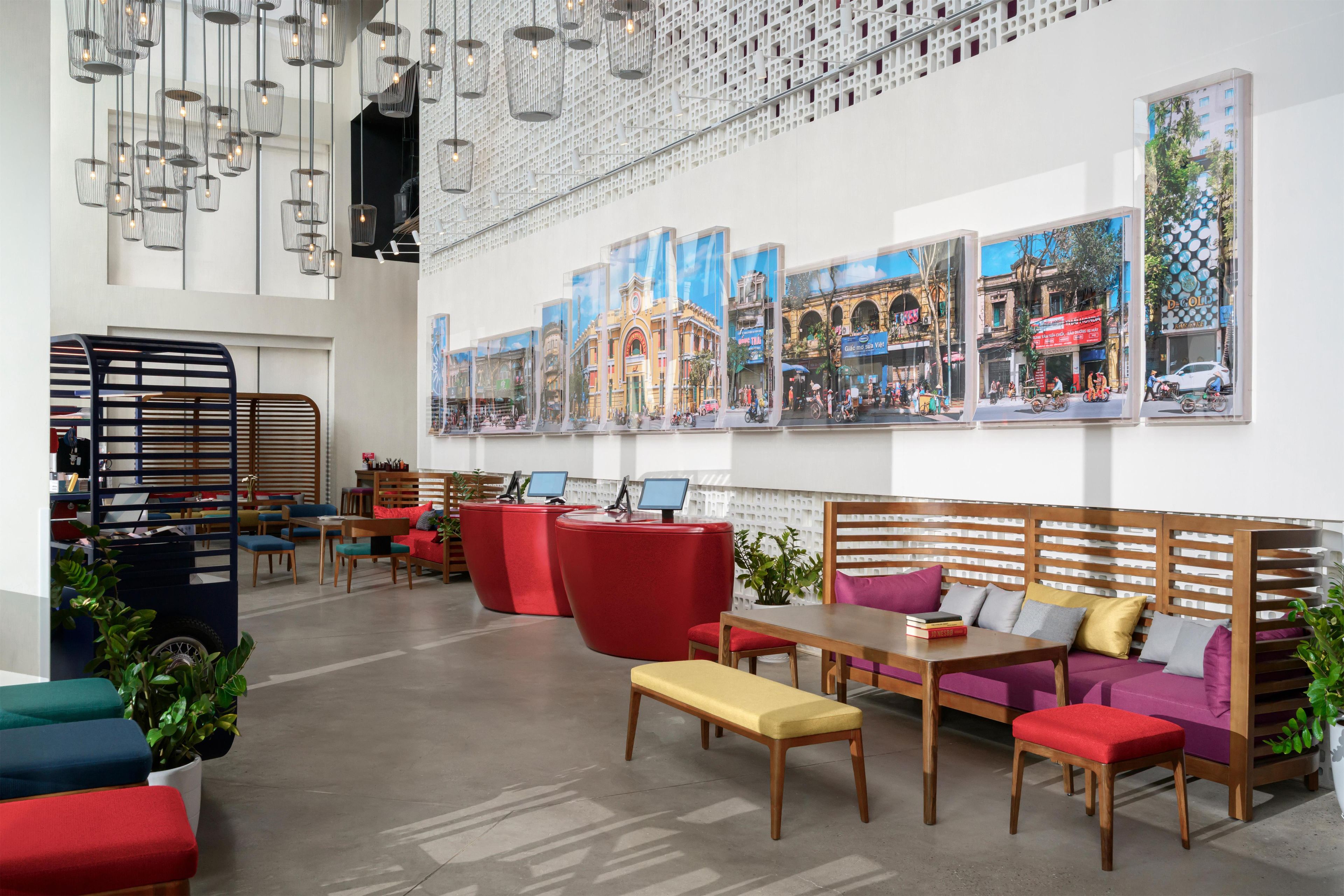 A modern interior with seating areas, tables, and a wall with cityscape photographs.