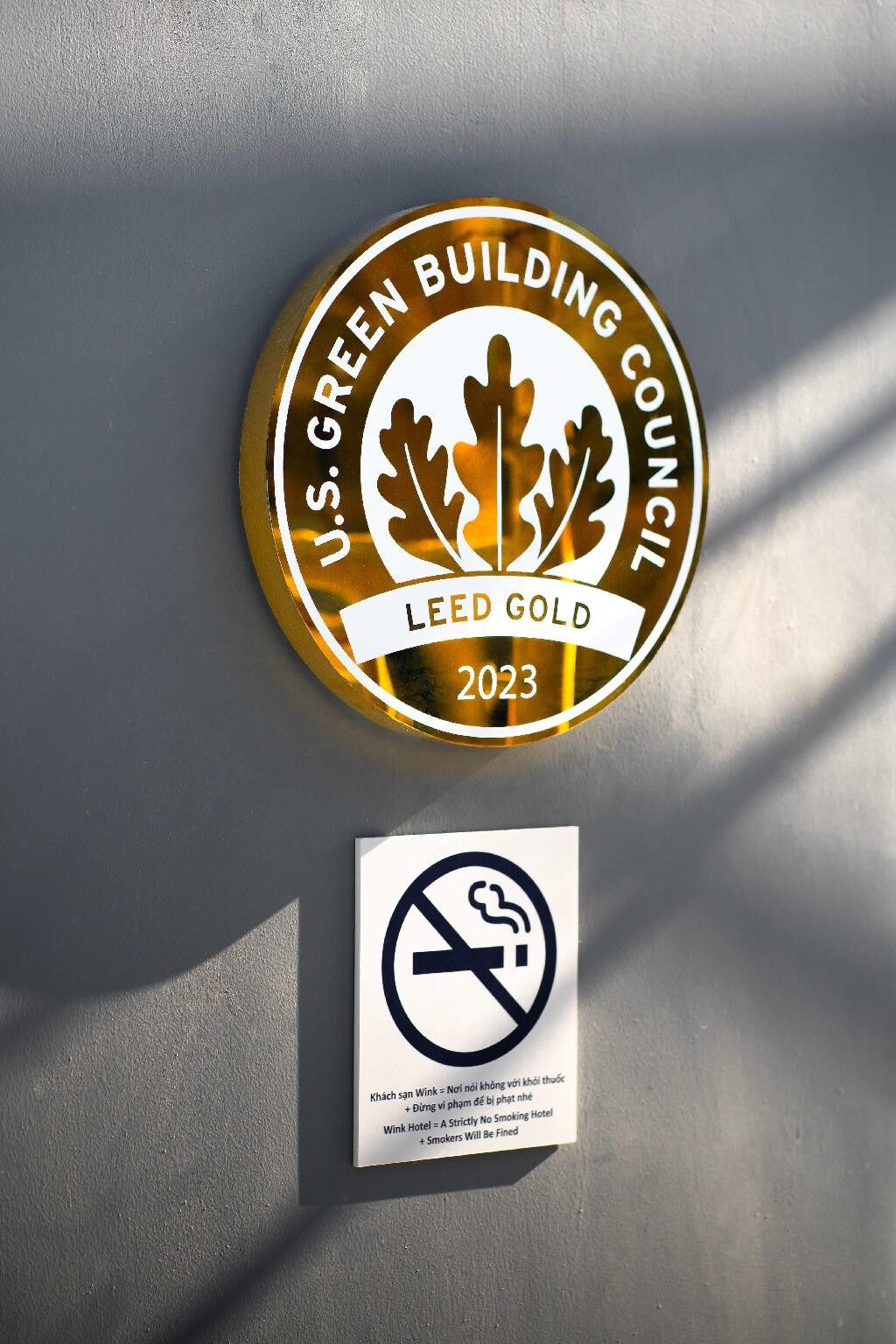 A circular emblem with "U.S. GREEN BUILDING COUNCIL LEED GOLD 2023" and a no-smoking sign below it.