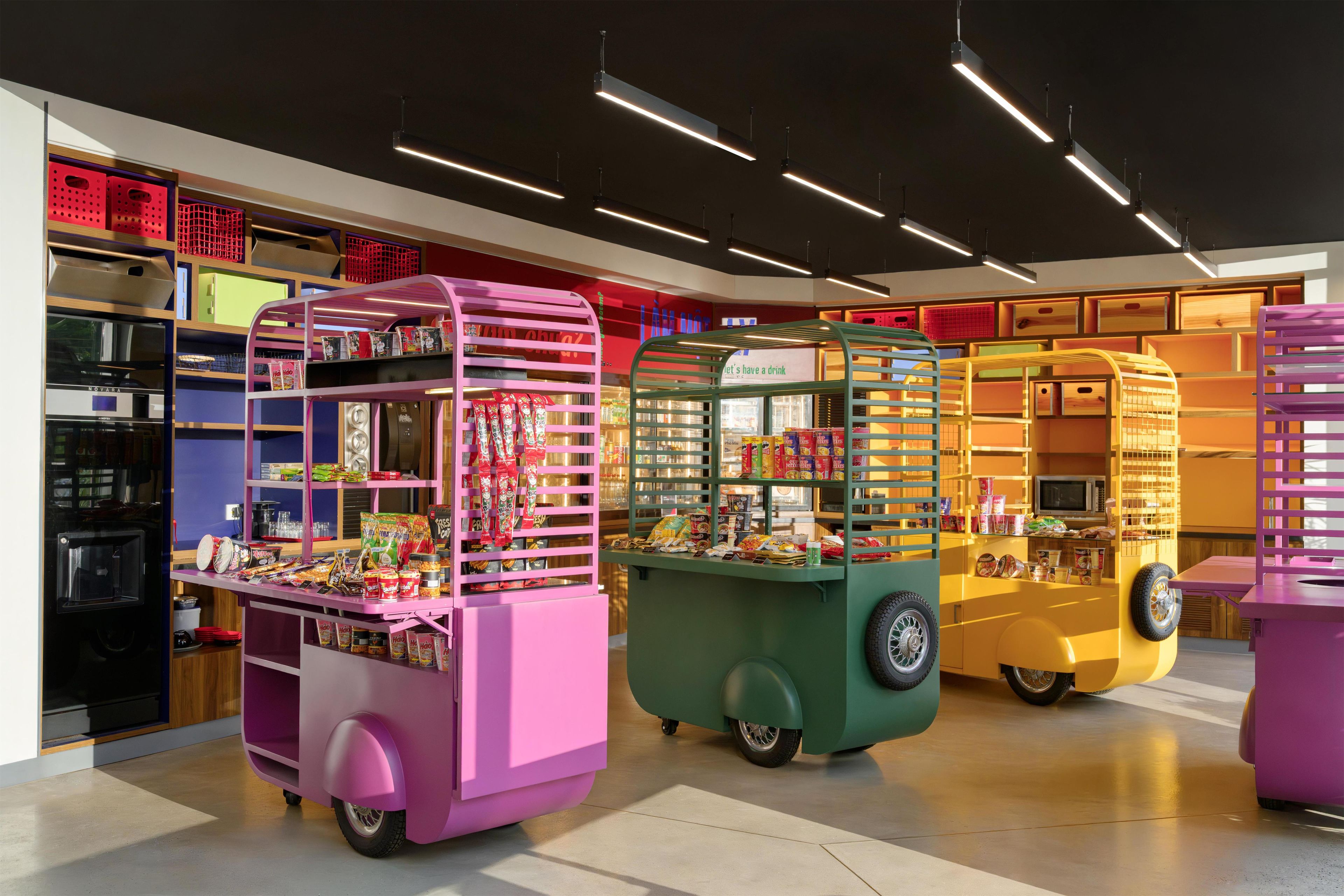 A brightly lit store with colorful vending carts selling snacks and drinks.