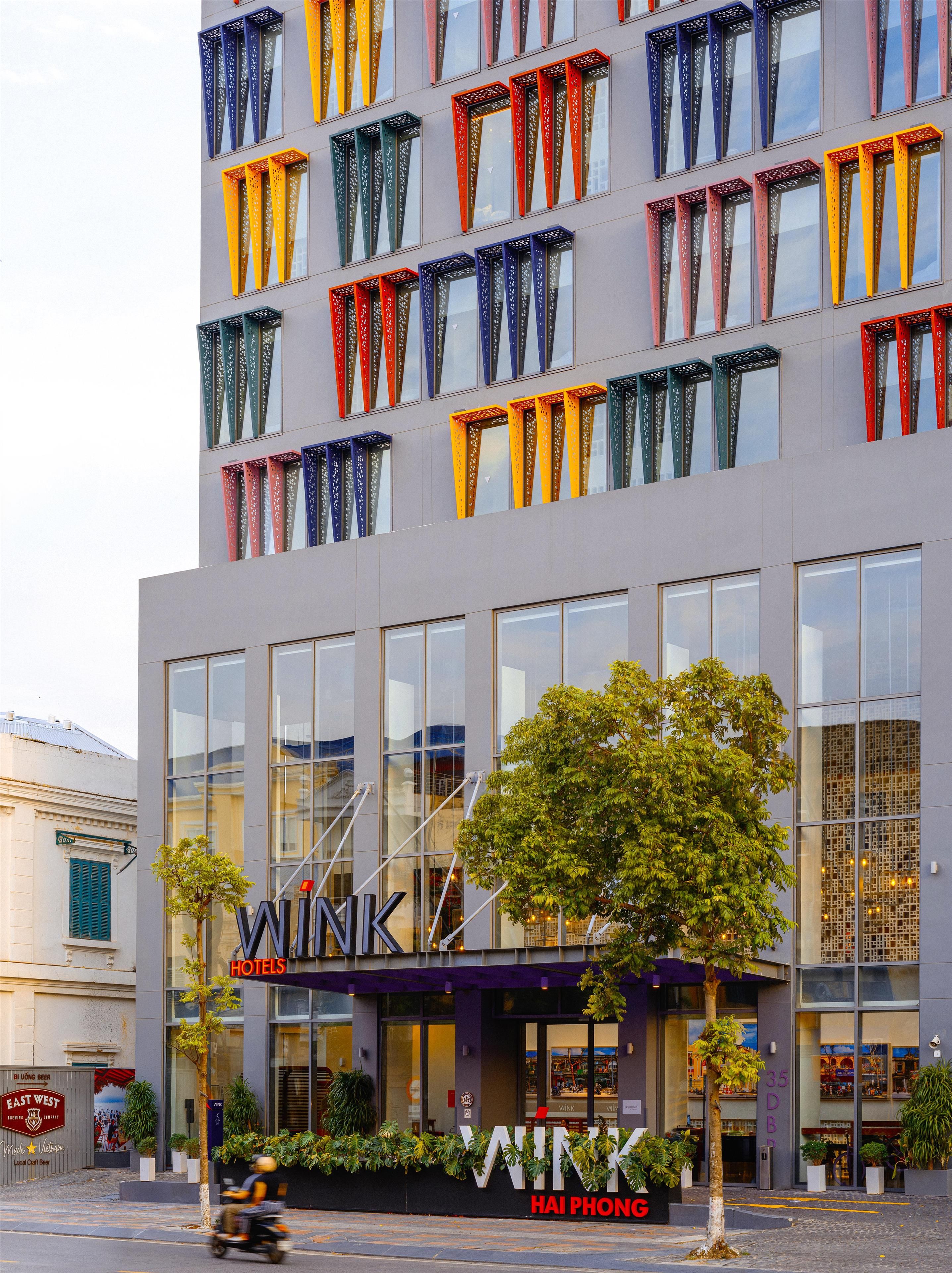 Ein Hotel mit einer modernen Fassade, großen Fenstern und einer gut sichtbaren Beschilderung.