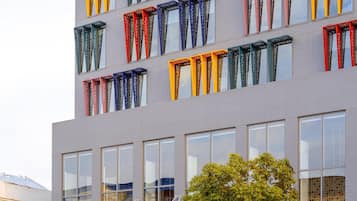 Ein Hotel mit einer modernen Fassade, großen Fenstern und einer gut sichtbaren Beschilderung.