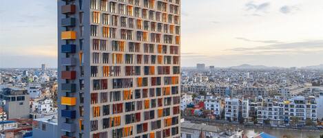 A high-rise building with a prominent 'WINK' sign, multiple balconies, and a view of the surrounding cityscape.