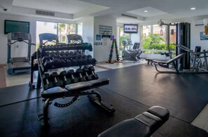 A gym with exercise equipment, including dumbbells, treadmills, and weight machines.