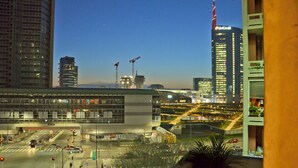 Stadsbeeld met moderne gebouwen, waaronder een hoge UniCredit-toren, en een drukke kruising met verkeerslichten en voertuigen.