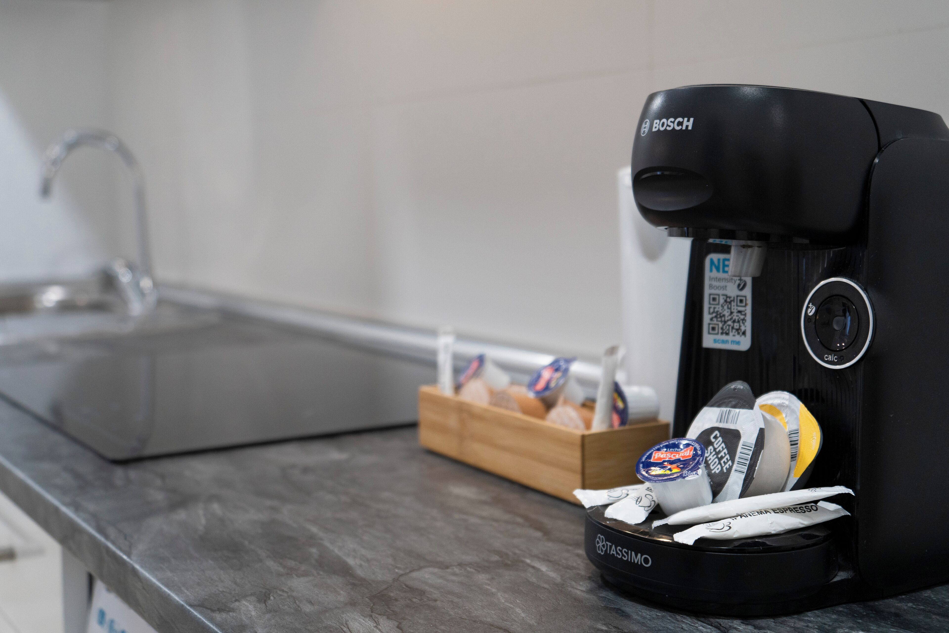 Una cafetera con un porta cápsulas de café sobre una encimera de cocina.