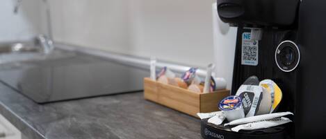 Una cafetera con un porta cápsulas de café sobre una encimera de cocina.