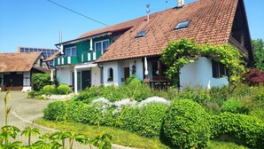 A traditional house with a tiled roof, a green facade, and a well-maintained garden. - House Apple Blossom - No 4 (Langenargen)