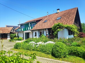 Traditional European-style house with a charming front porch and lush garden.