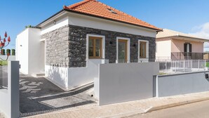 A modern house with a stone facade, a tiled roof, and a gated entrance. - Exceptional stone character house |Chalet Prazeres (Prazeres)