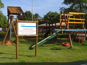 Children can play on the slide, swings, and climbing frames in this safe and natural playground area.
