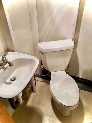 A small bathroom with a white sink and toilet. - 1966 Shasta Cottage w/AC - Durham, NC (Durham)