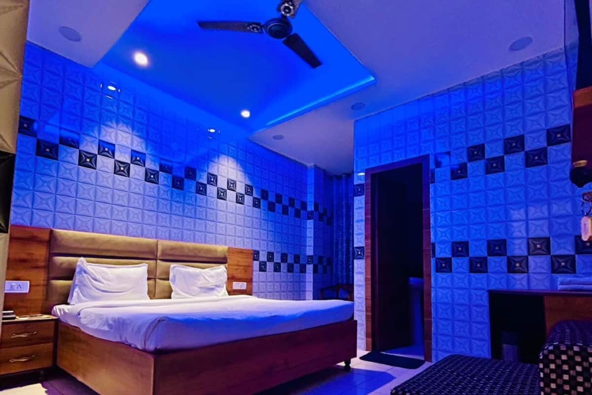 Une chambre à coucher avec un lit, un ventilateur de plafond et un mur décoré de motifs.