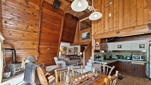 Un interior rústico de madera con comedor, cocina y sala de estar.