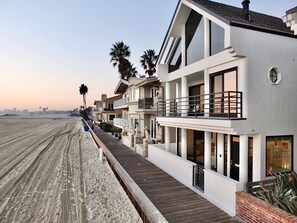 A beachfront property with a wooden boardwalk, white buildings, and palm trees. - Beachfront, Crow's Nest 360 Degree Views, Sleeps 6 (Long Beach)