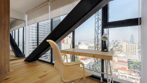 Ein moderner Büroraum mit einem großen Fenster, einem Schreibtisch, einem Stuhl und Blick auf die Stadt.