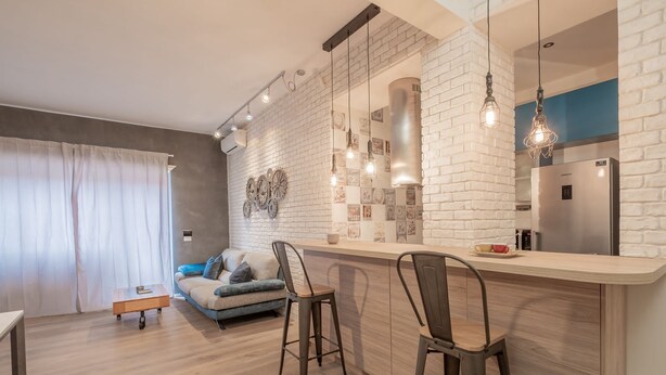 A modern kitchen with a white brick backsplash, stainless steel appliances, and pendant lighting.