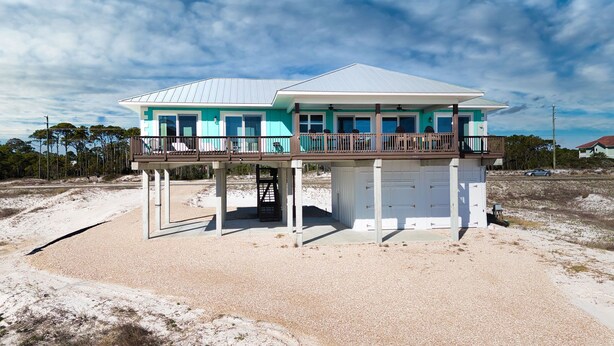 A two-story beachfront house with a balcony and a covered garage. - Dragonfly Shores - Beach View, Pet Friendly, Beach Gear Credit Included! (St George Island)