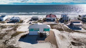A coastal property with multiple houses, a sandy beach, and the ocean in the background. - Dragonfly Shores - Beach View, Pet Friendly, Beach Gear Credit Included! (St George Island)