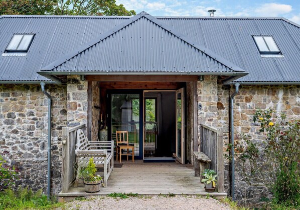 Stunning stone building with a welcoming entrance, featuring a porch and glass door.